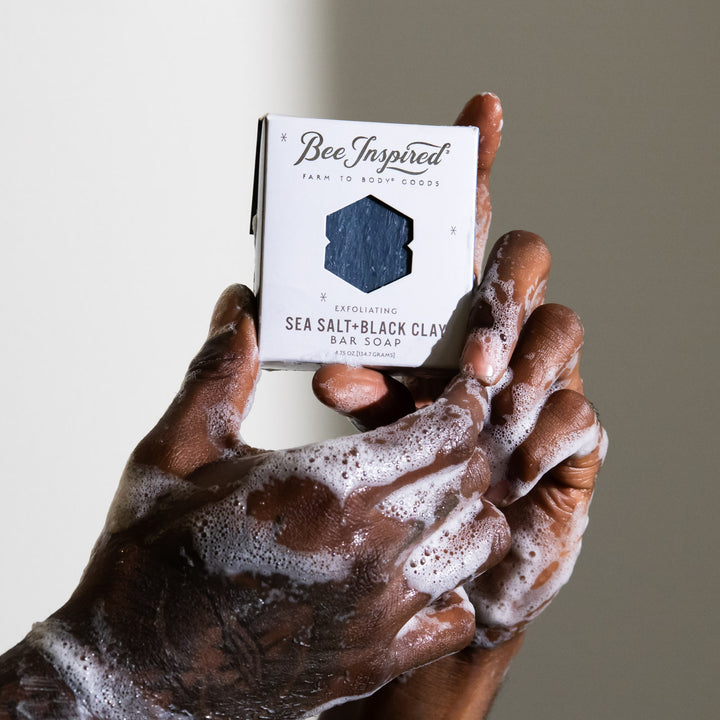 soapy hands holding sea salt + black clay bar soap