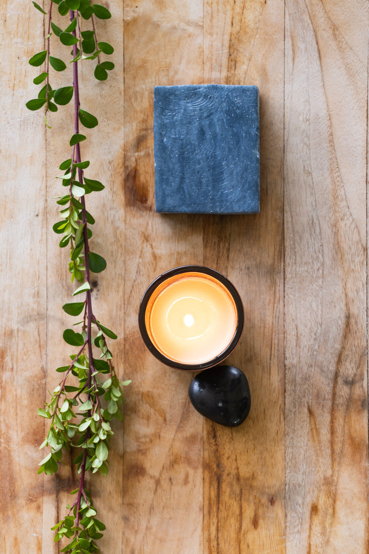 Black clay bar soap with burning candle 