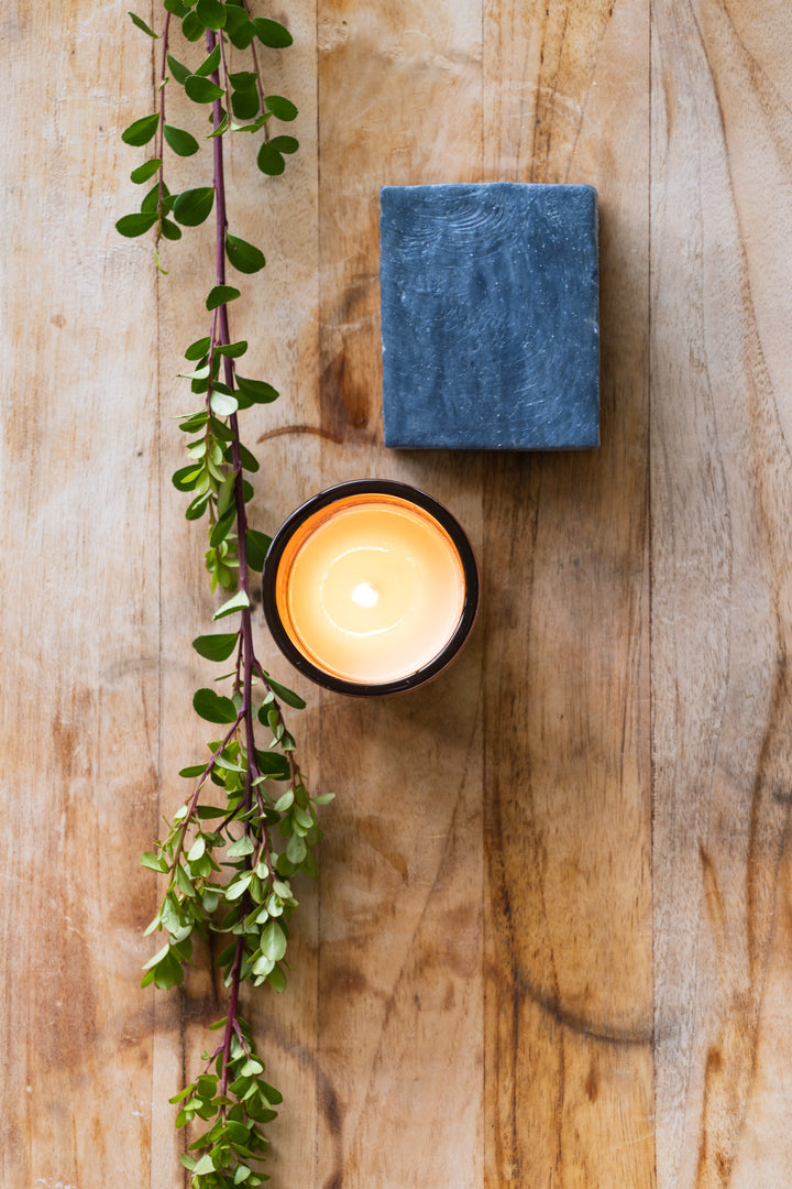 Black clay bar soap with burning candle 