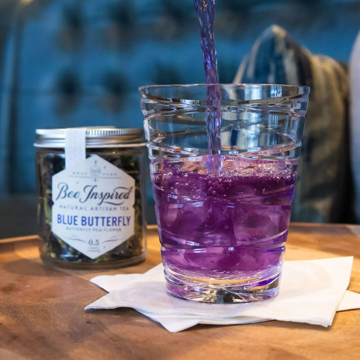 pouring a glass of iced Blue Butterfly tea with lemonade