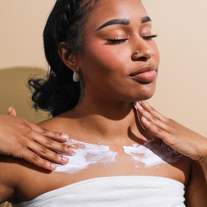 A woman using Citrus Blossom body butter on her chest and shoulders