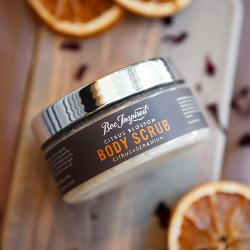 Citrus blossom scrub on wood with geranium petals and orange wheels