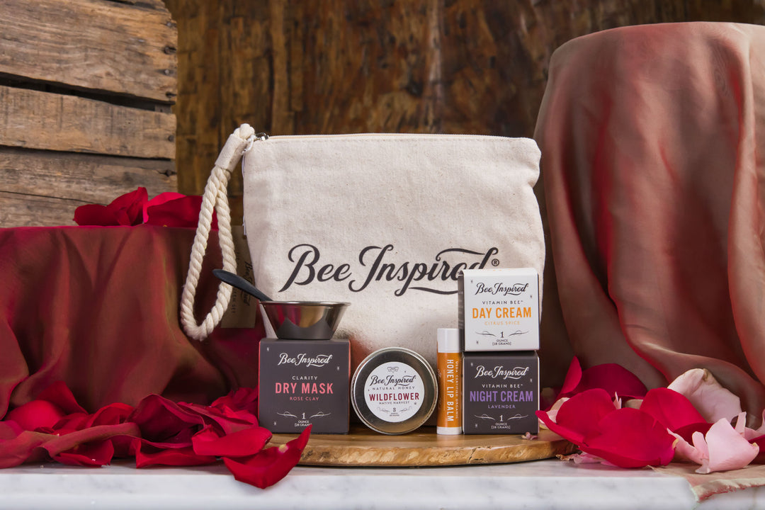 Bee Inspired skincare products on a wooden board with a beige tote bag against a rustic wooden background.