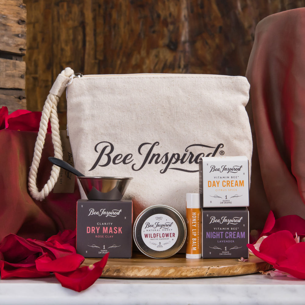 Bee Inspired skincare products on a wooden tray with a branded bag in the background.