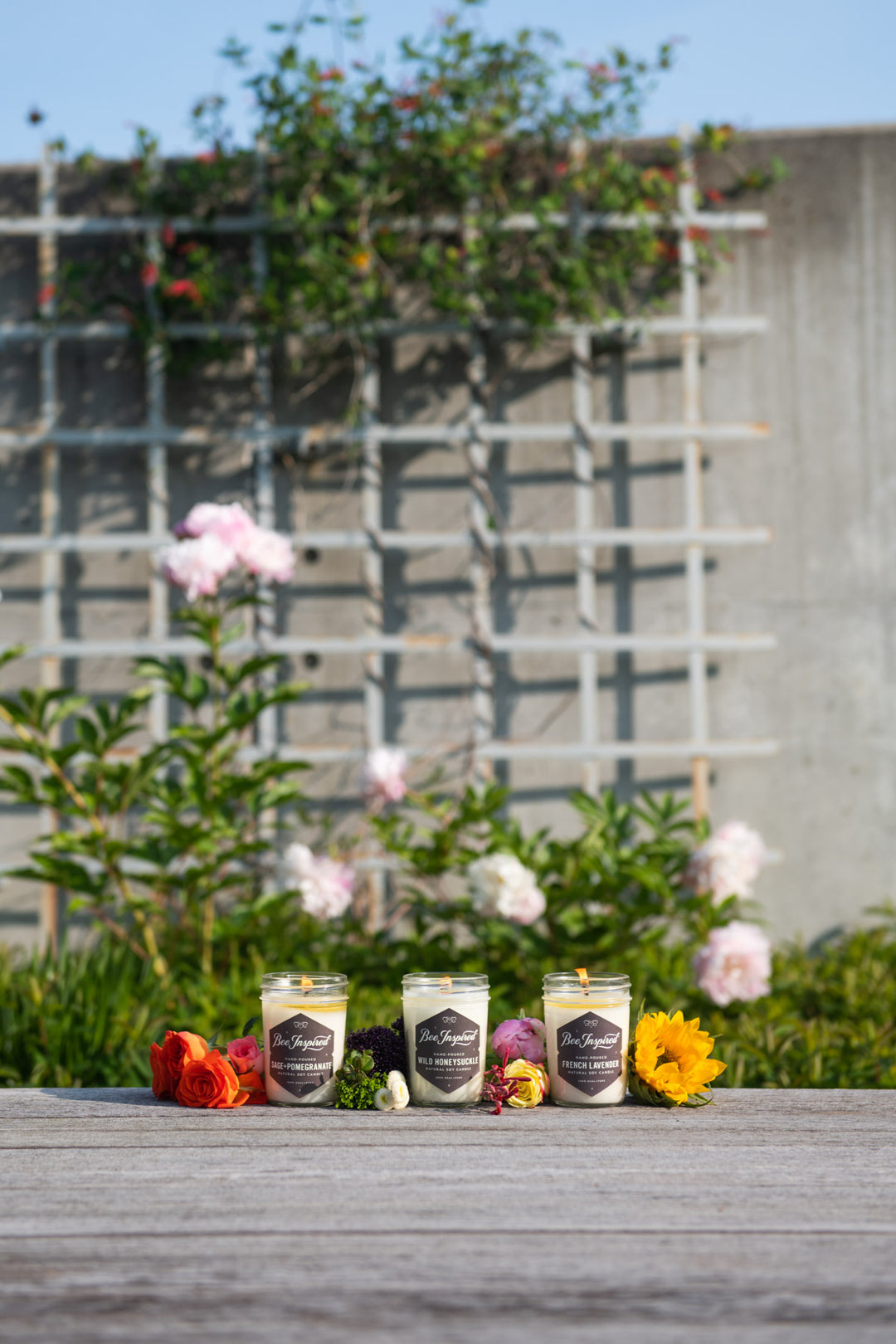 Garden jelly jar candle set burning next to flowers 