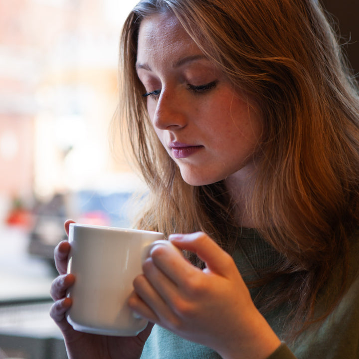 Woman holds mug of tea 