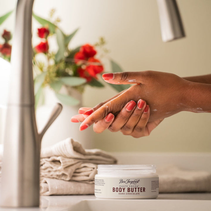 applying haute cocoa body butter to hands