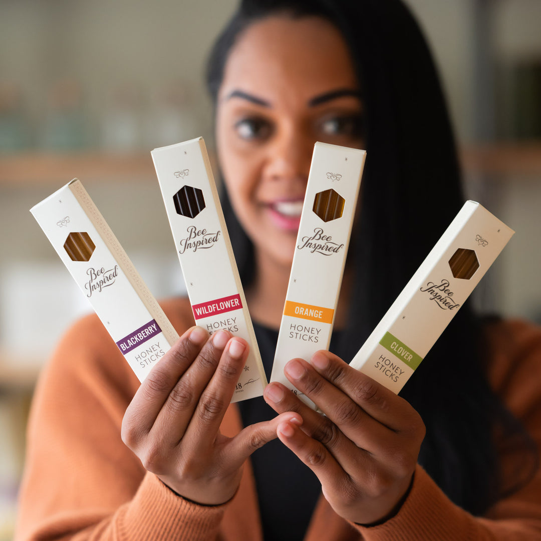 Woman holding boxes of varietal honey sticks 