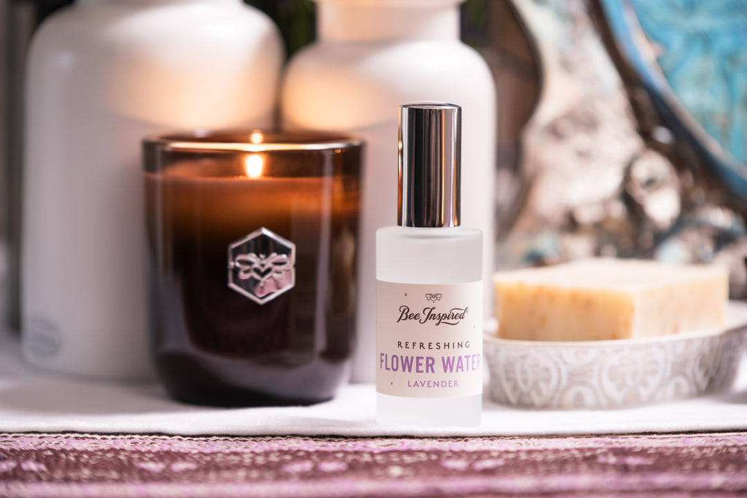 Bee Inspire lavender flower water in front of a luxe candle and bar of lavender oatmeal soap 