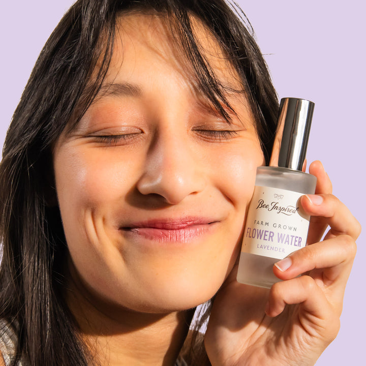 woman smiling and holding lavender flower water