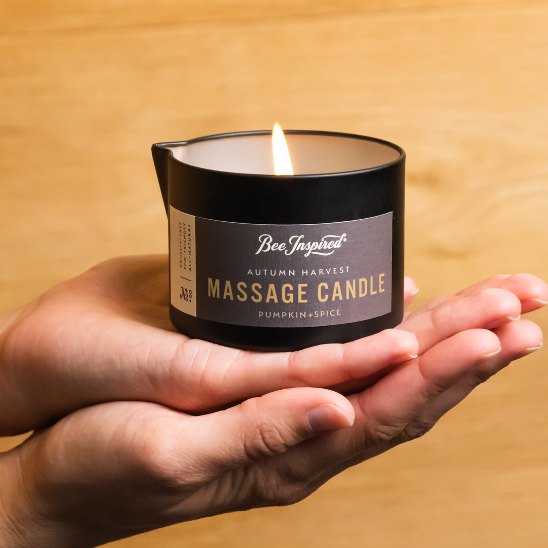 hands holding a lit autumn harvest massage candle