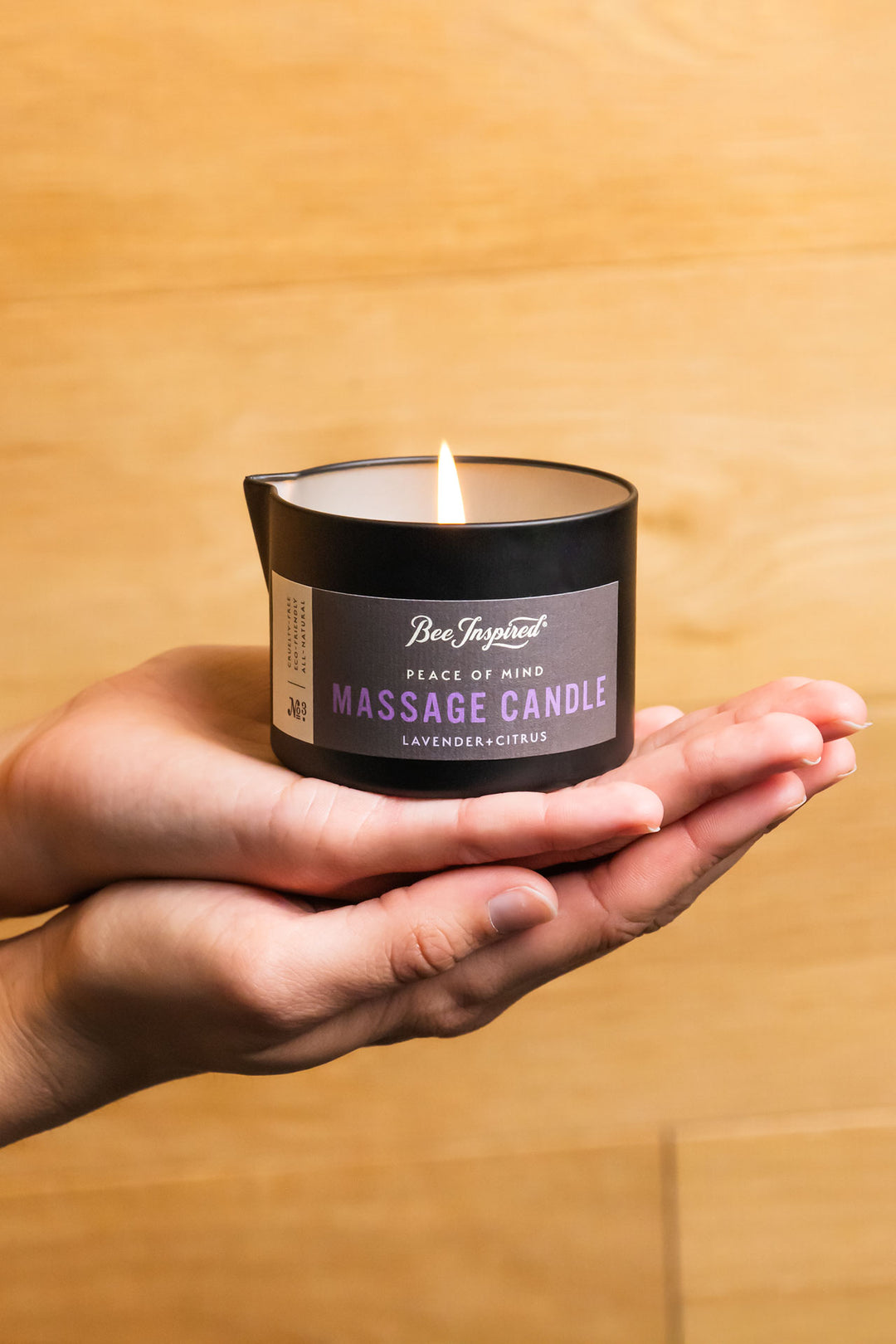 hands holding a lit peace of mind massage candle