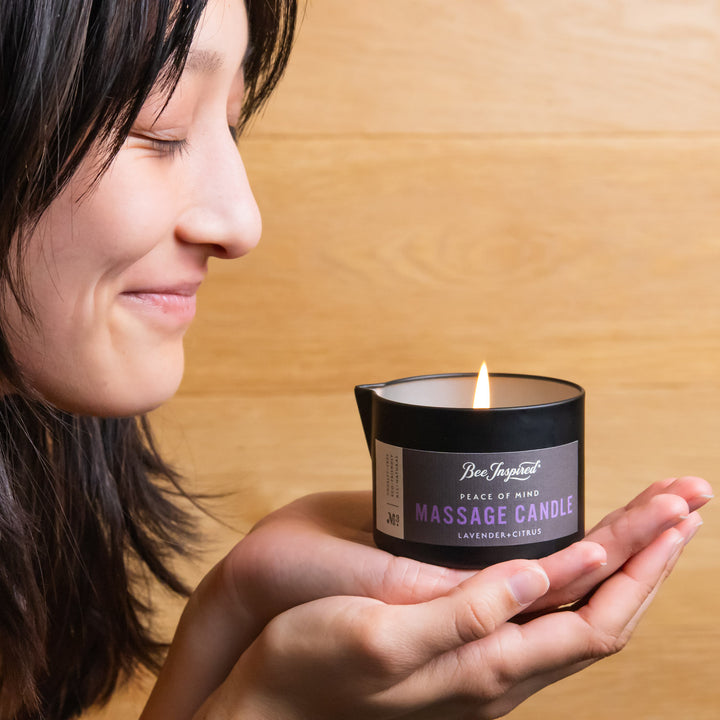 woman holding a lit peace of mind massage candle