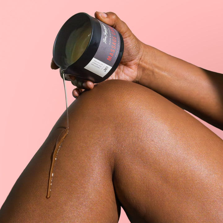 pouring Rose Garden massage candle oil on leg