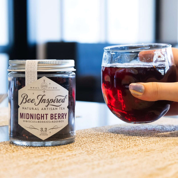holding a glass of iced Midnight Berry tea