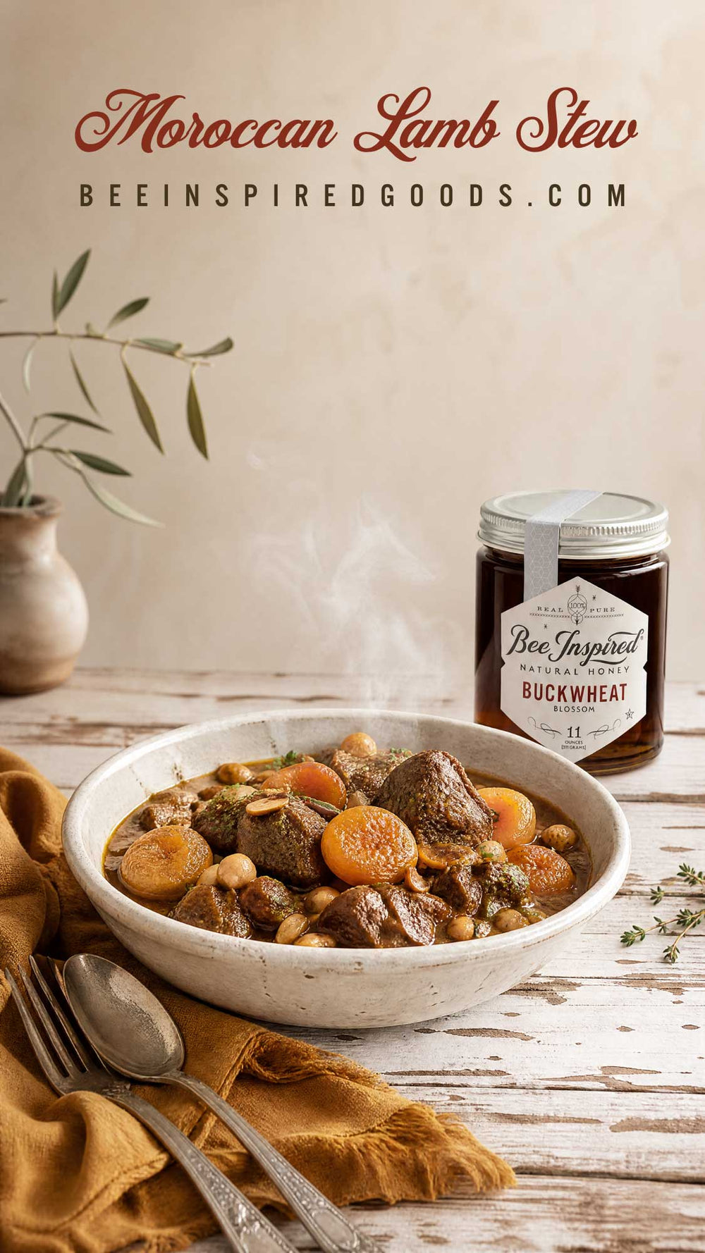 A bowl of Moroccan Lamb Stew filled with lamb, carrots, and chickpeas, styled on a rustic wooden table with a jar of bee inspired buckwheat flour and a spoon in the foreground.