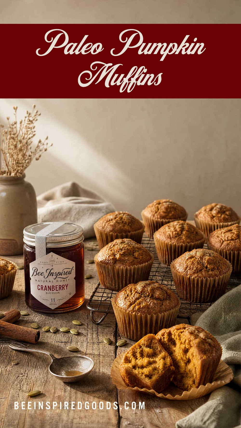 Paleo pumpkin muffins baked on a rustic wooden table with a jar of cranberry jam, cinnamon sticks, and a metal spoon. A dark red banner at the top reads 'Paleo Pumpkin Muffins' and a website URL is shown at the bottom.