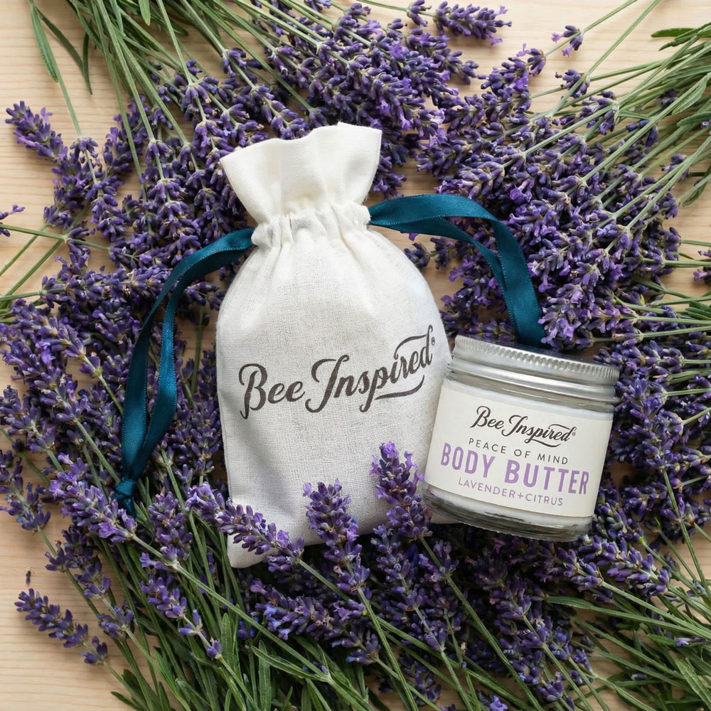 Body butter jar and pouch with lavender flowers on a wooden surface