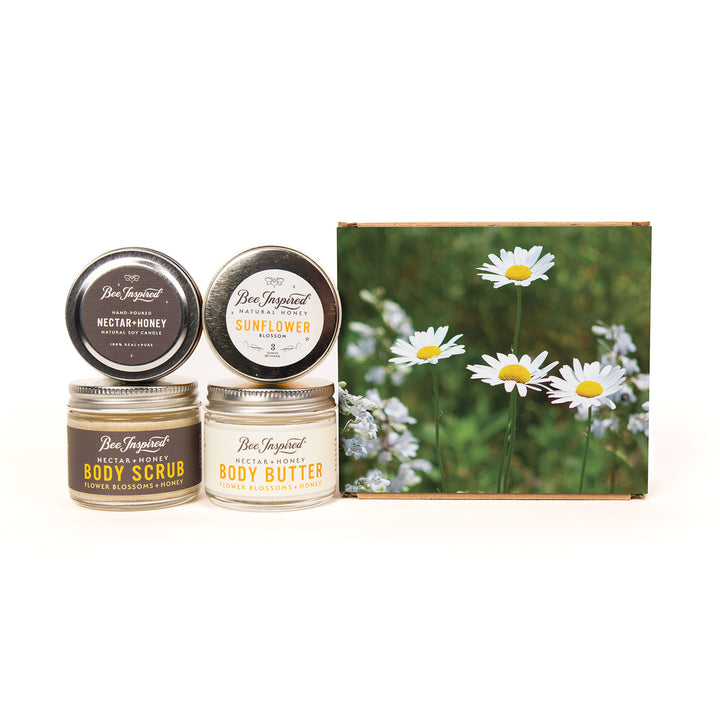 Set of Bee Inspired body care products with a card featuring daisies on a white background