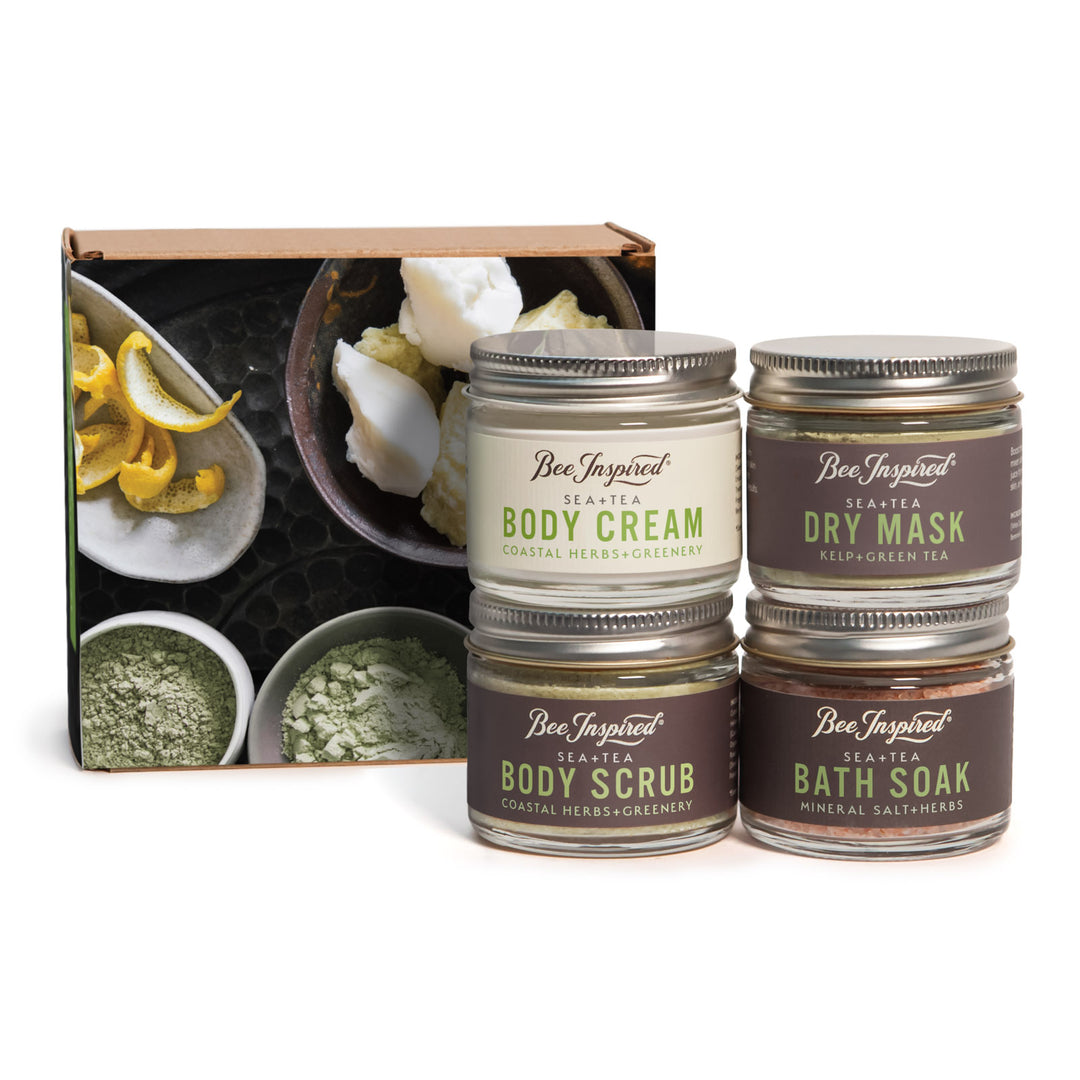 Set of Bee Inspired body care products including cream, scrub, mask, and soak with a decorative box in the background.