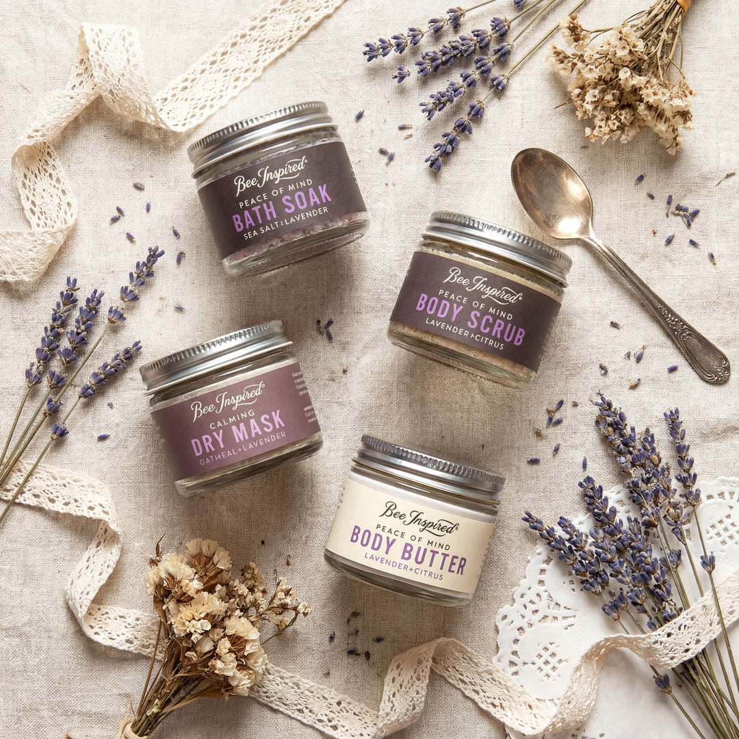 Set of Bee Inspired skincare products with lavender on a textured surface