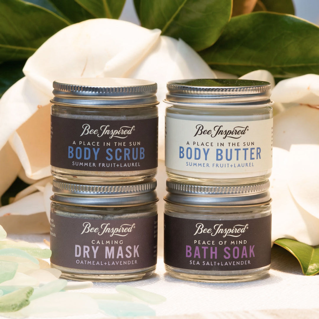 Four containers of Bee Inspired body care products with floral background