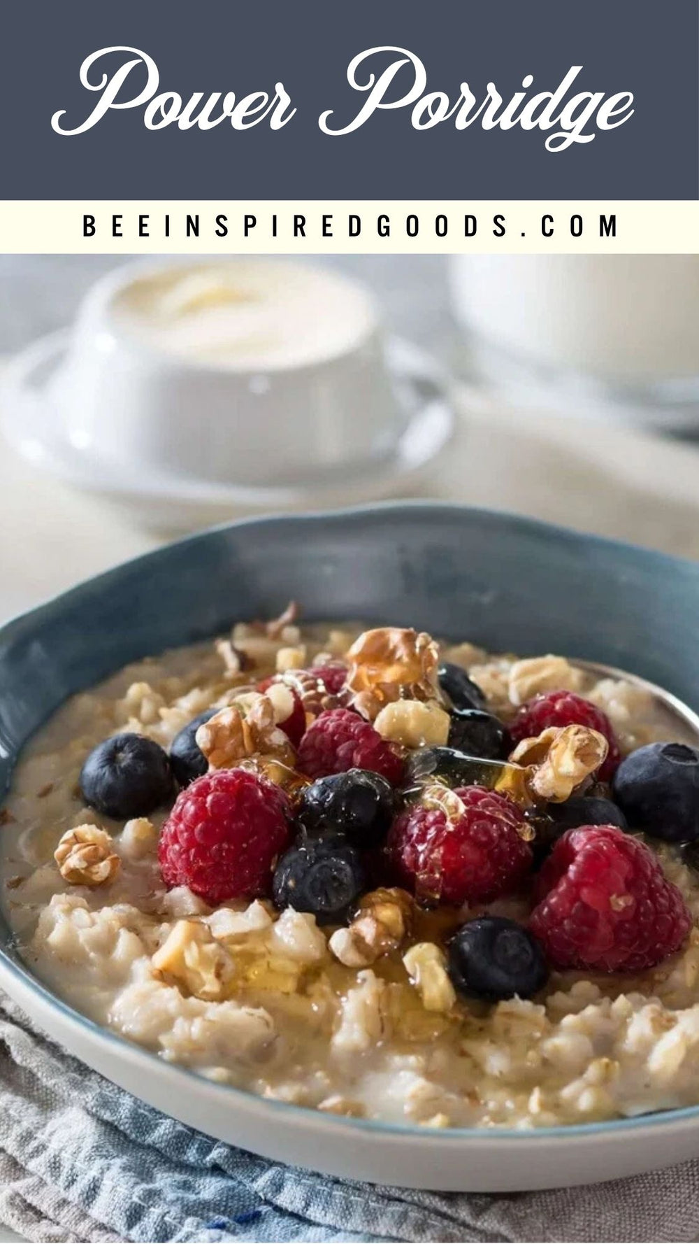 A bowl of creamy power porridge topped with fresh raspberries, blueberries, and chopped walnuts, with a blurred background showing a cup and a glass of milk. Text overlays at the top read 'Power Porridge' and 'BEEINSPIREDGOODS.