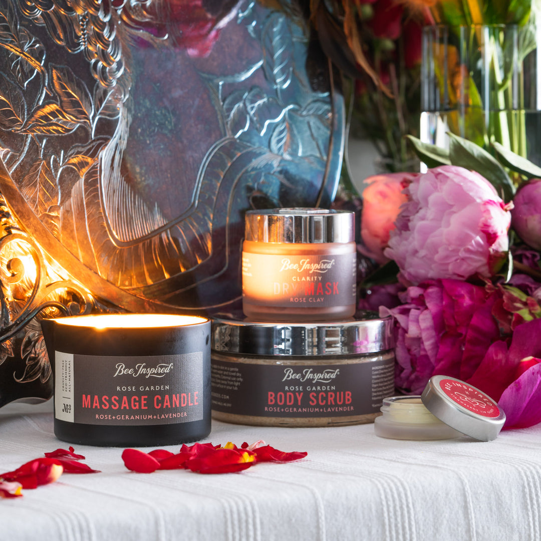 rose garden body scrub, rose garden massage candle, clarity dry mask, and strawberry lip gloss on a boudoir set
