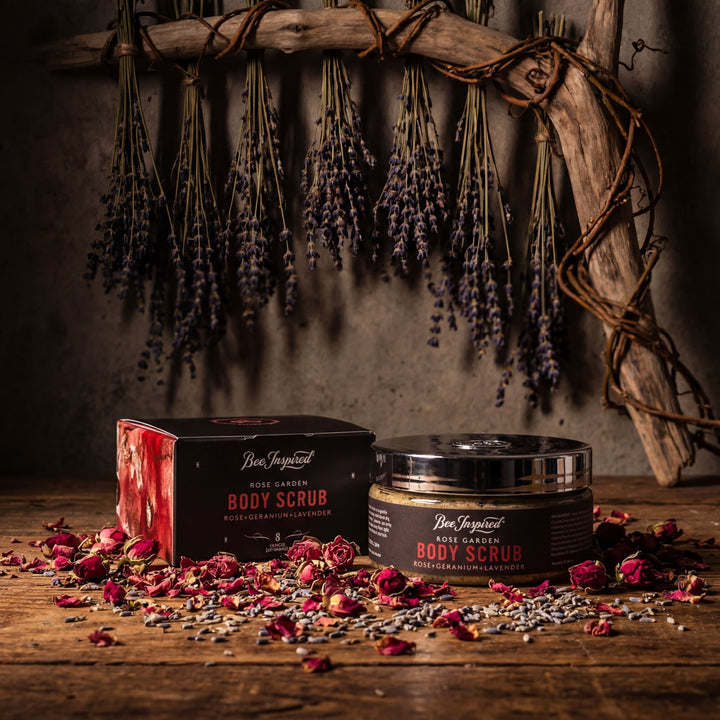 Body scrub packaging with lavender and rose petals on a wooden surface
