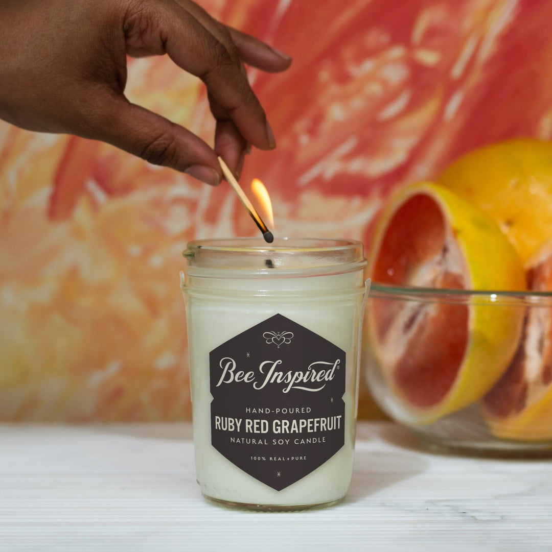 Ruby Red Grapefruit Jelly Jar Candle being lit by hand