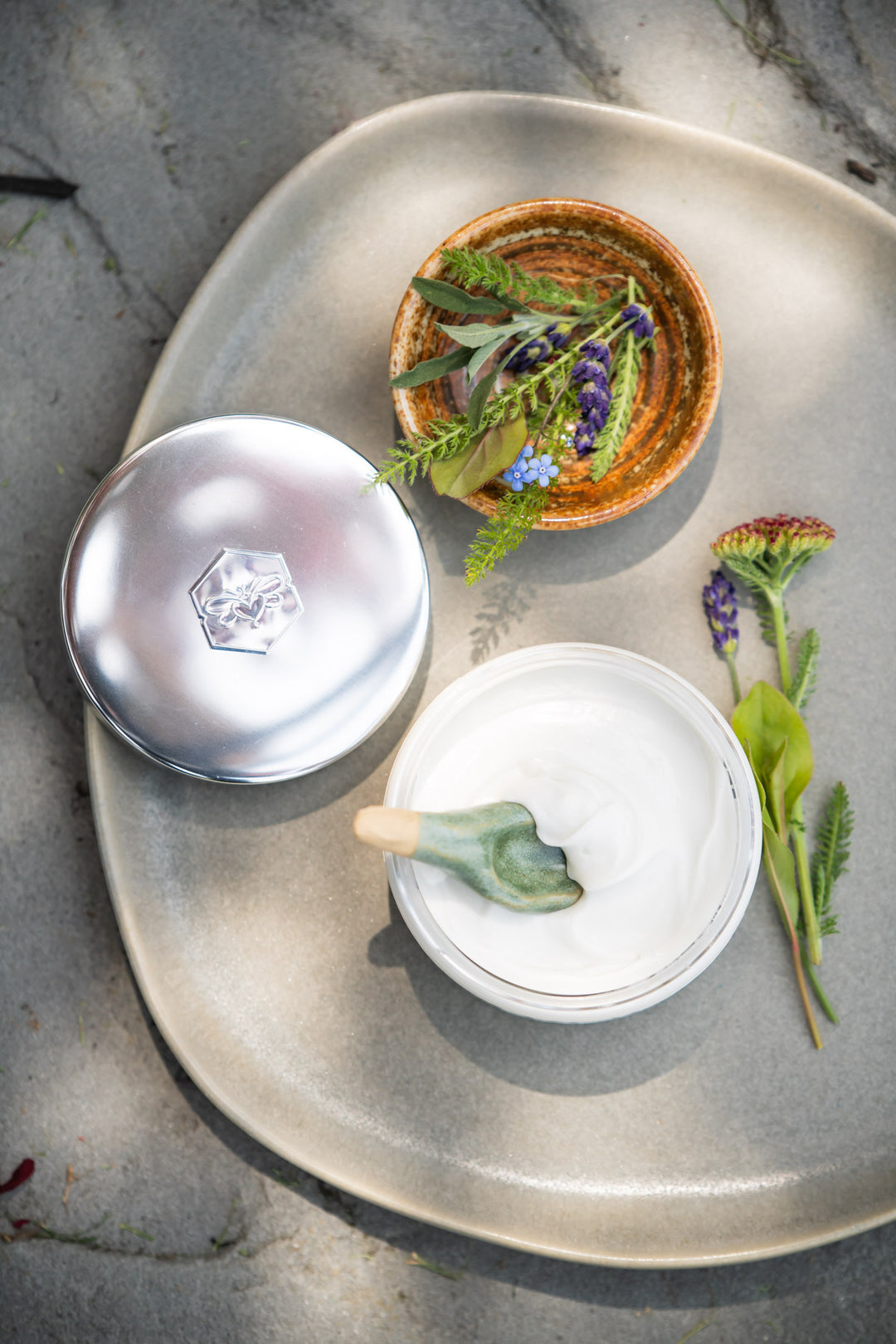 sea+tea cream from bee inspired honey retail store in owings mills on a plate with a small bowl full of greenery