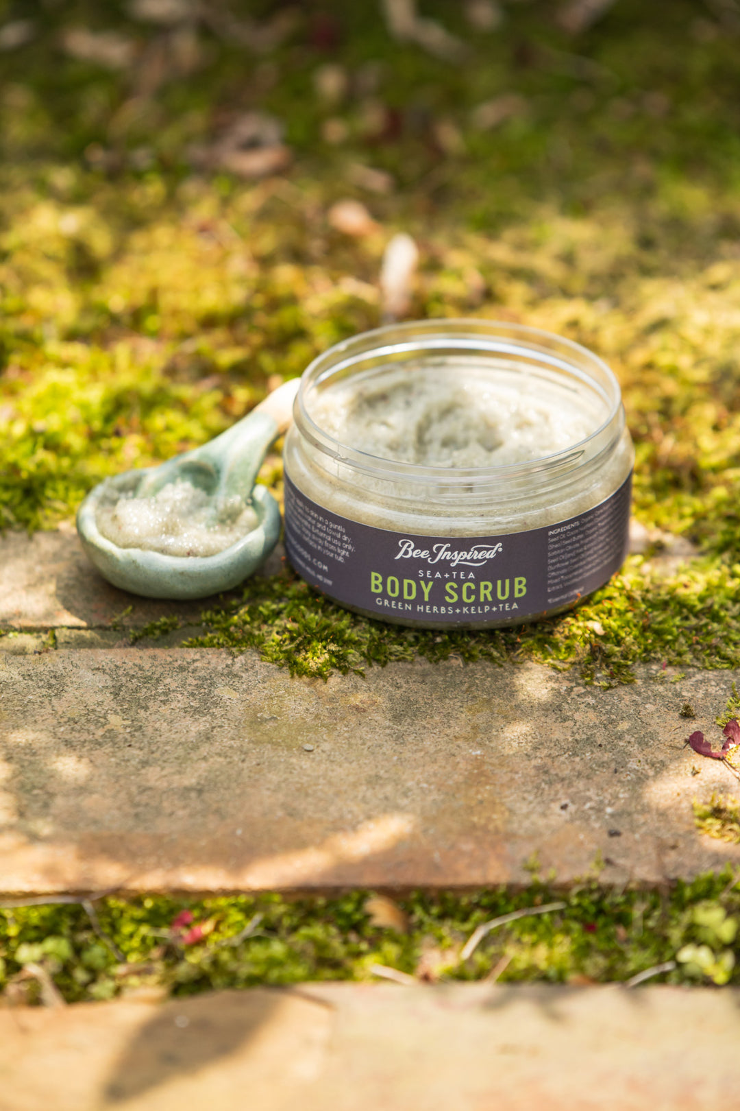 sea+tea scrub from bee inspired honey retail store in owings mills on the grass with a small bowl filled with scrub