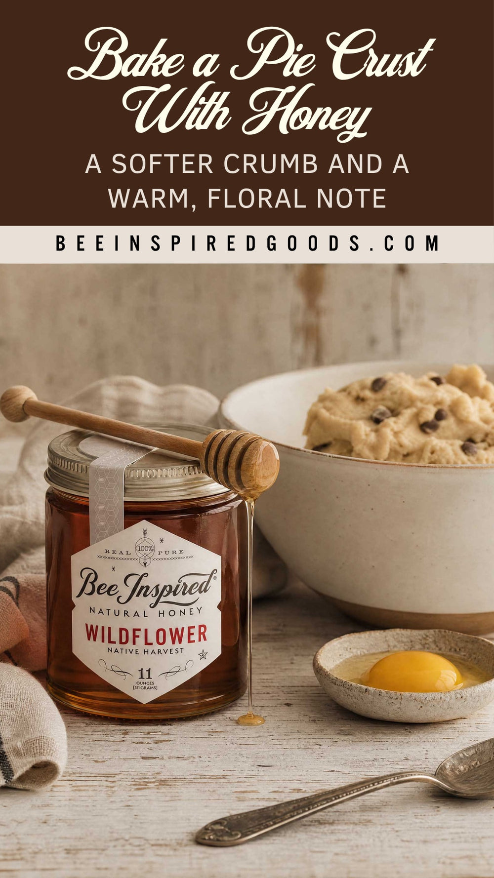 Jar of Bee Inspired Wildflower honey with a pie crust and lemon on a wooden surface.