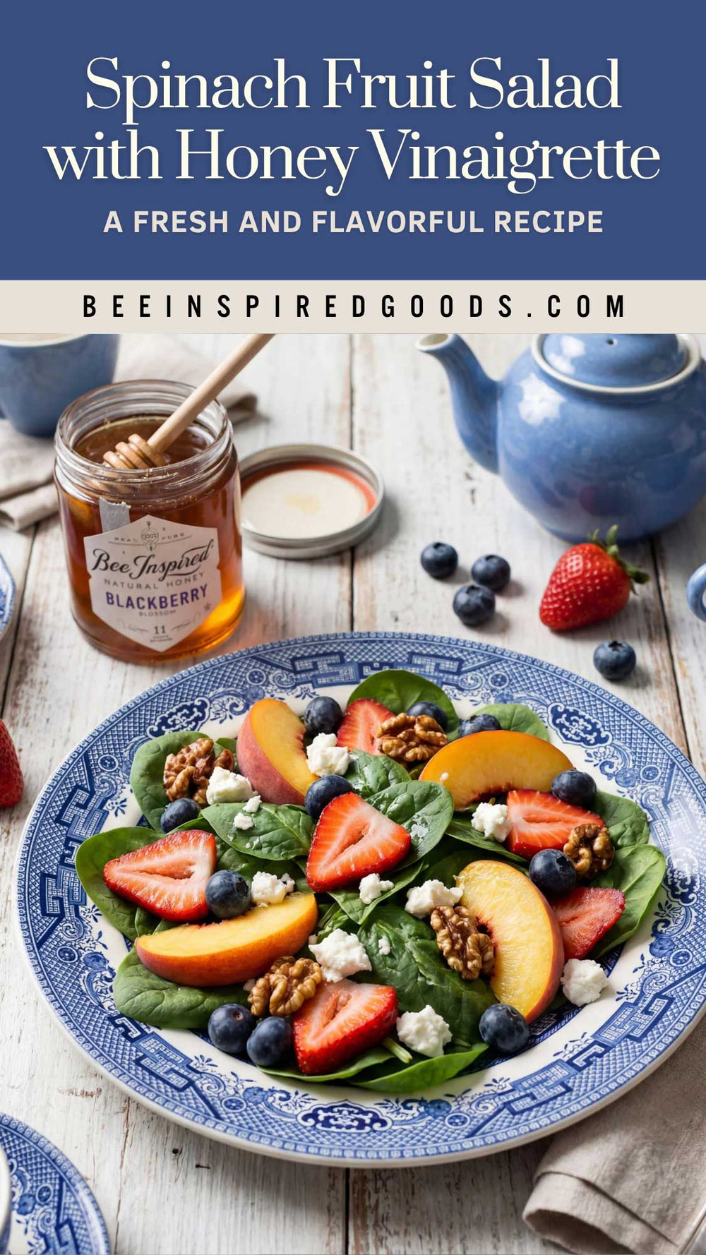 A plated spinach fruit salad with strawberries, peaches, blueberries, walnuts, and honey vinaigrette on a rustic white wooden table, with a jar of honey, a blue teapot, and the text 'Spinach Fruit Salad with Honey Vinaigrette' at the top.