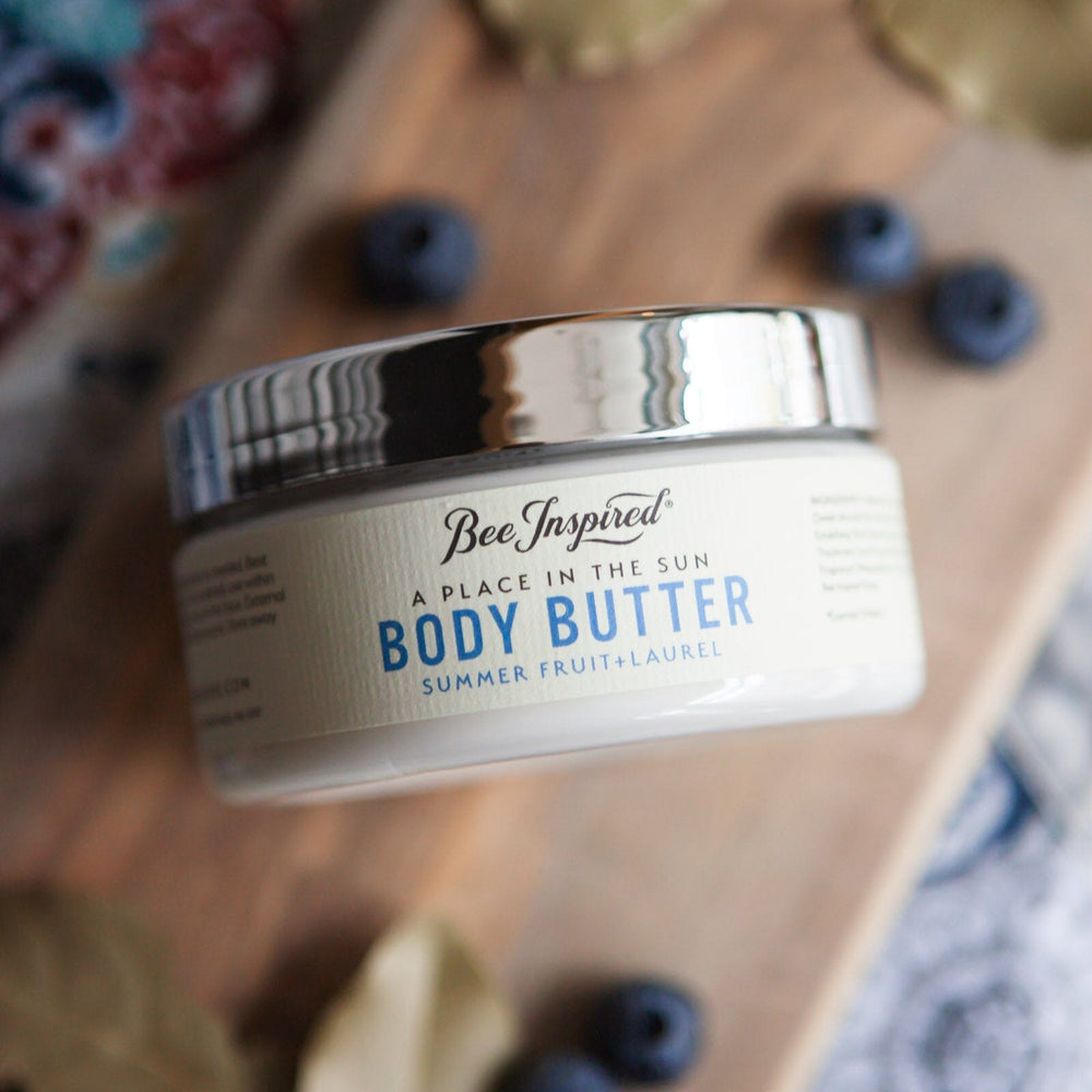 Sun Body Butter on wood with ingredients