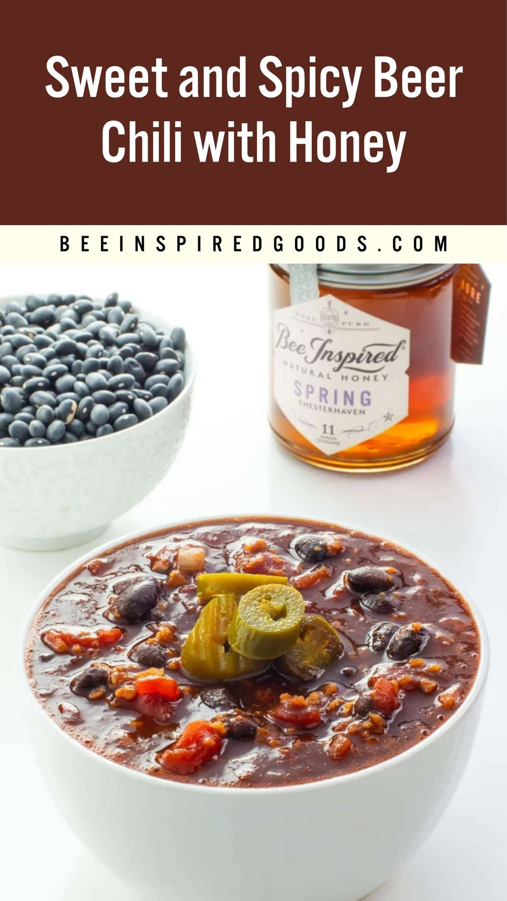 A bowl of Sweet and Spicy Beer Chili with Honey, topped with sliced pickles, shown alongside a bowl of black beans and a jar of Bee Inspired Goods Spring Beer Infused Honey. The top of the image features a brown banner with the text 'Sweet and Spicy Beer Chili with Honey' and the website 'BEEINSPIREDGOODS.