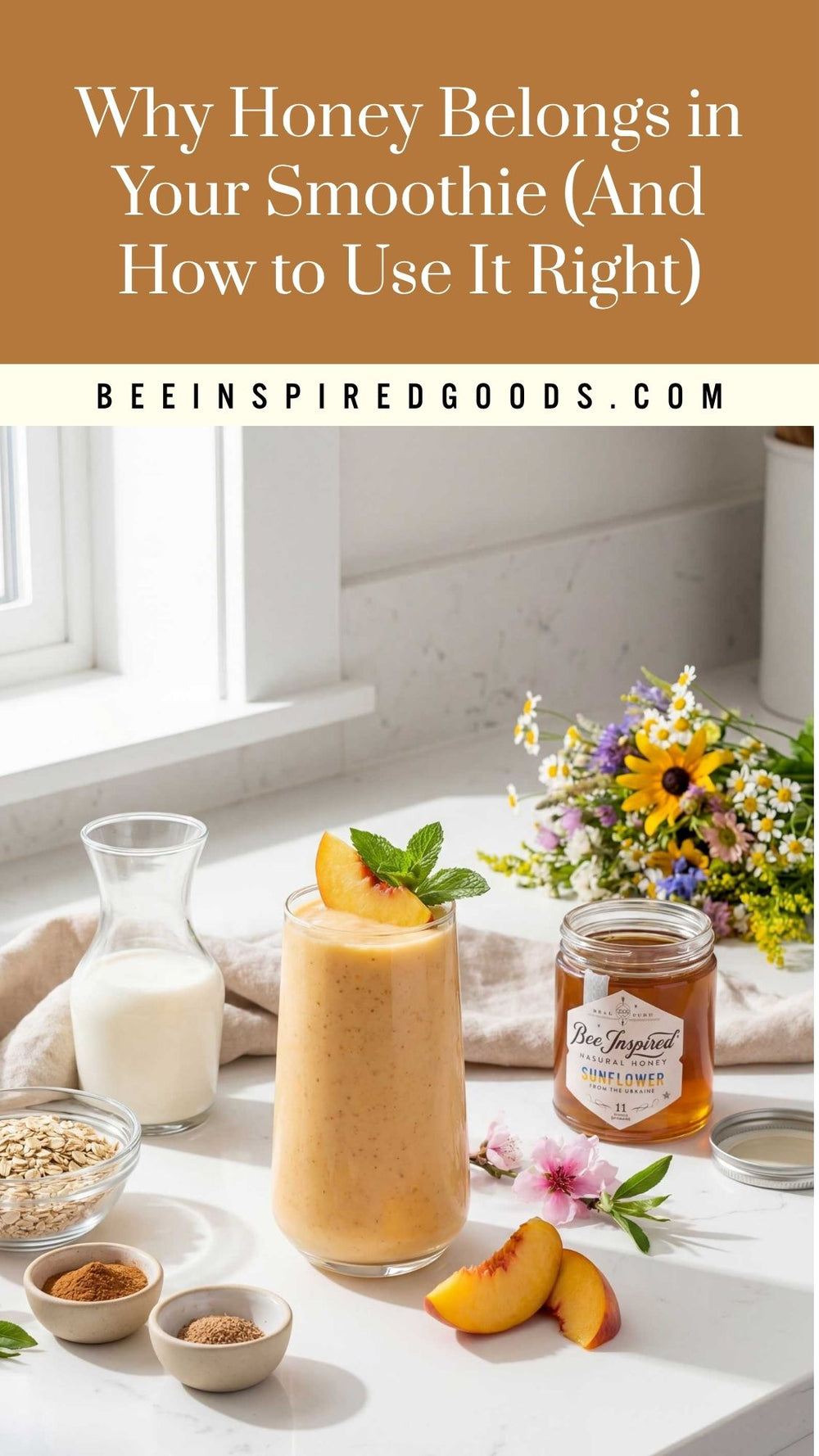 A glass of orange smoothie with peach slices and mint garnish on a white countertop, alongside a jar of honey, a small bottle of milk, oats, spices, and flowers. Text at the top reads 'Why Honey Belongs in Your Smoothie (And How to Use It Right)' with 'BEEINSPIREDGOODS.