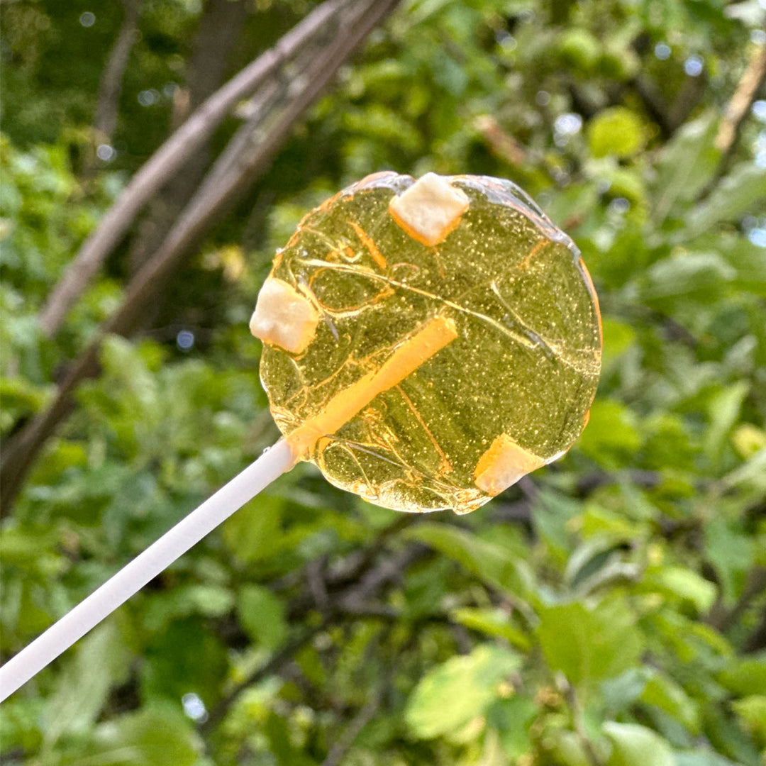 Apple honey lollipop in front of nature background 