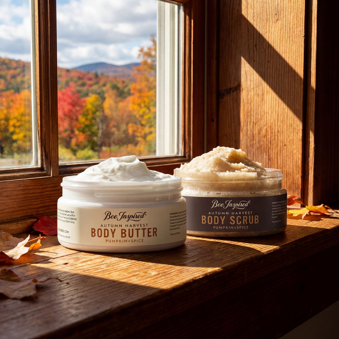 Two jars of 'Bee Inspired' body products on a windowsill with autumn foliage outside.