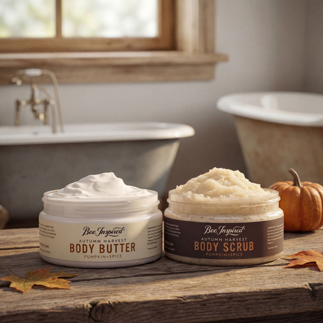 Two jars of 'Bee Inspired' body products on a wooden surface with a bathtub and pumpkin in the background.