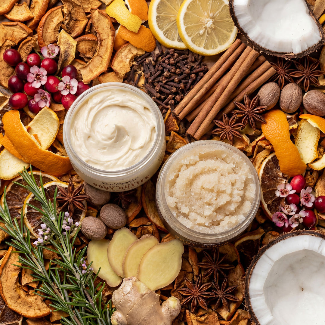 Two jars of cream or scrub surrounded by spices, citrus fruits, and flowers on a textured surface.