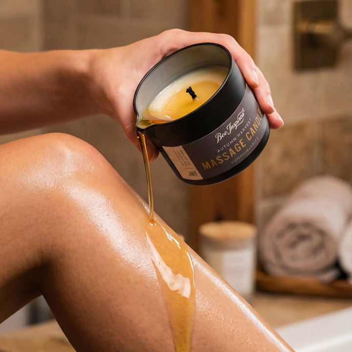 Person using a massage candle on their leg in a bathroom setting