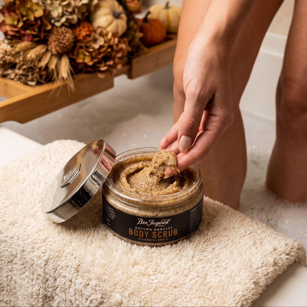 Person applying body scrub from a jar with decorative elements in the background