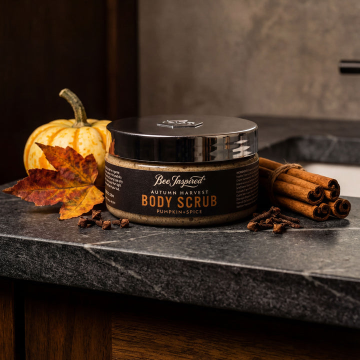 Jar of 'Autumn Harvest' body scrub with pumpkins and cinnamon sticks on a dark surface