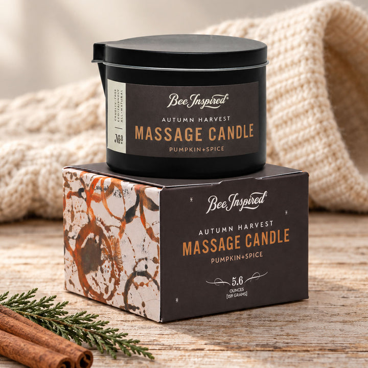 Bee Inspired Autumn Harvest Massage Candle with holiday trimmings on wood table