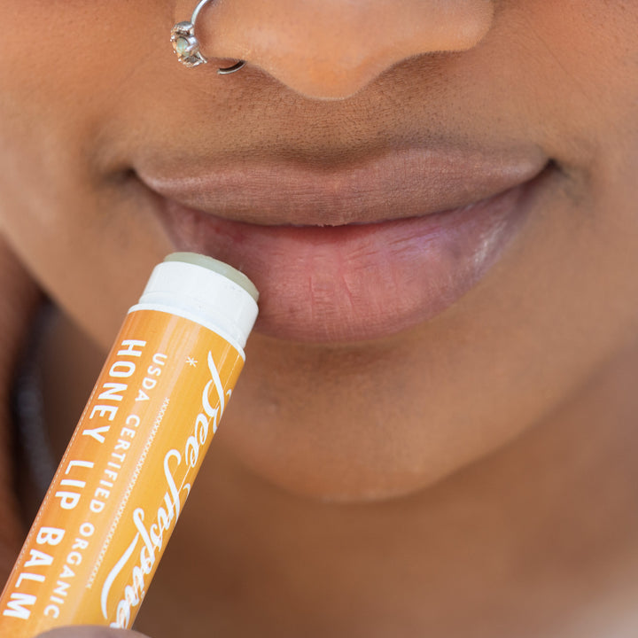 Closeup of woman applying lip balm 
