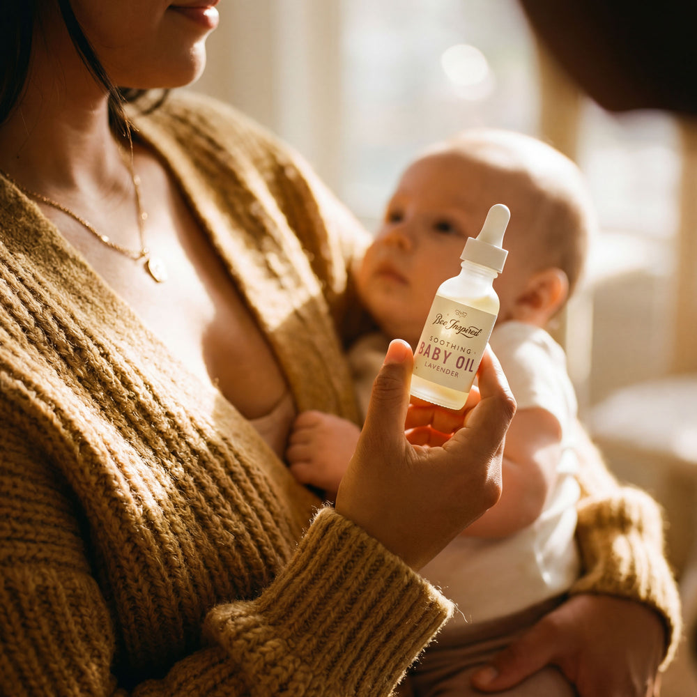 Woman holding a baby and a bottle of soothing baby oil in a warm indoor setting