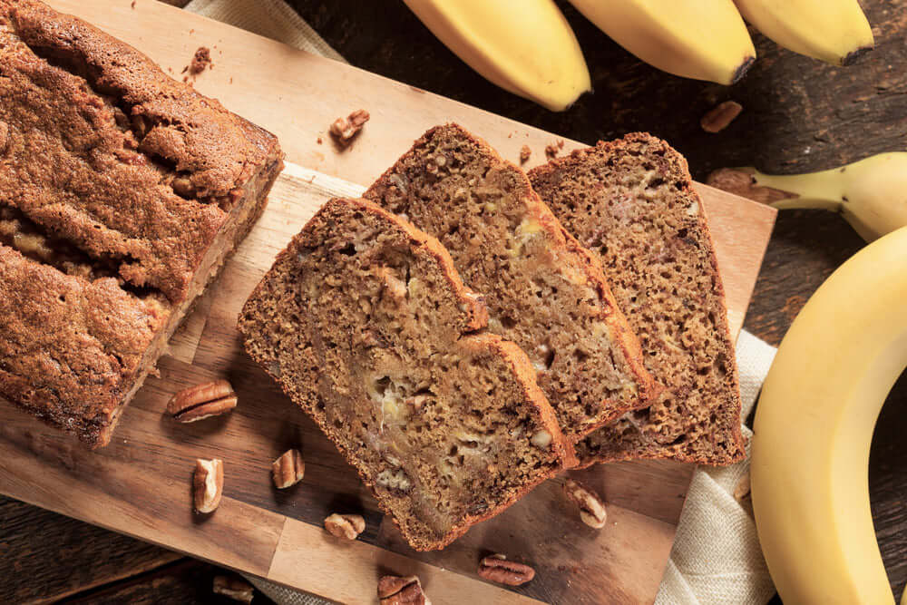 Honey banana bread loaf with slices on a cutting board