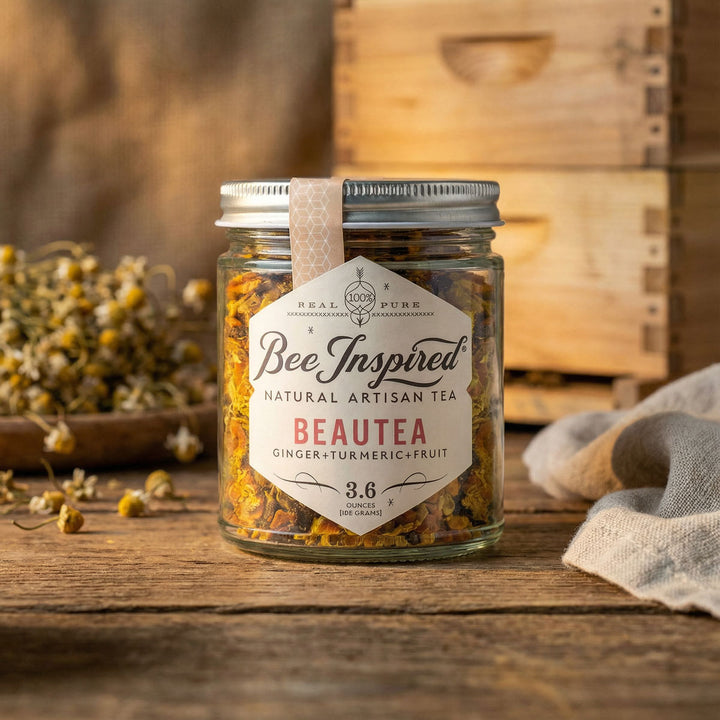 Jar of 'Bee Inspired' Beautea tea on a wooden surface with a hive in the background