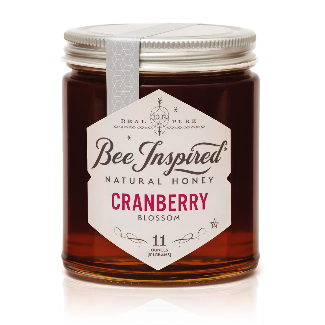Jar of Bee Inspired Cranberry Blossom honey on a white background